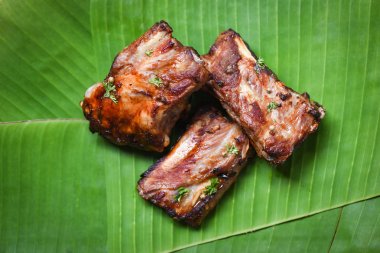 muz yaprağı nda servis edilen otlar baharatile ızgara bbq domuz kaburga - 