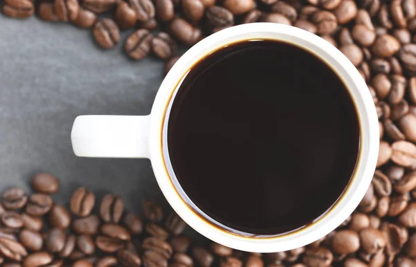 Coffee cup on roasted coffee beans on the dark background Royalty Free Stock Images