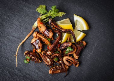 koyu arka plan üst limon otlar ve baharatlar ile ahtapot salatası