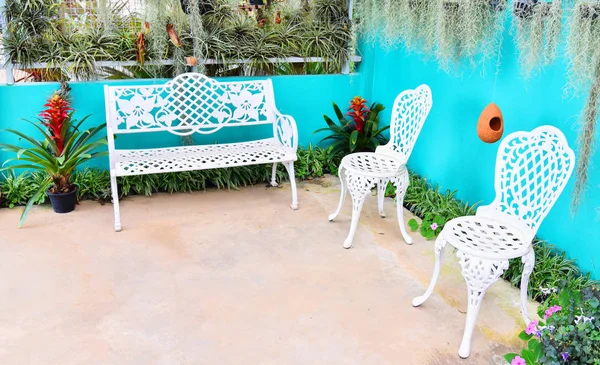 Vintage bänk och stol i trädgården blommor med grön växt h — Stockfoto