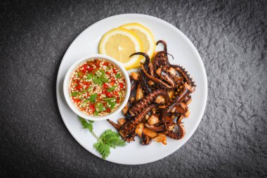 Beyaz tabakta limon otlar ve baharatlar ile Ahtapot salatası / Tenta