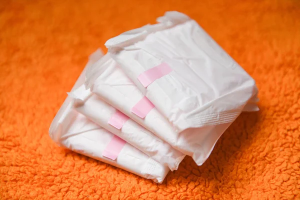 Sanitary napkin or feminine sanitary pad on a orange knitted bla