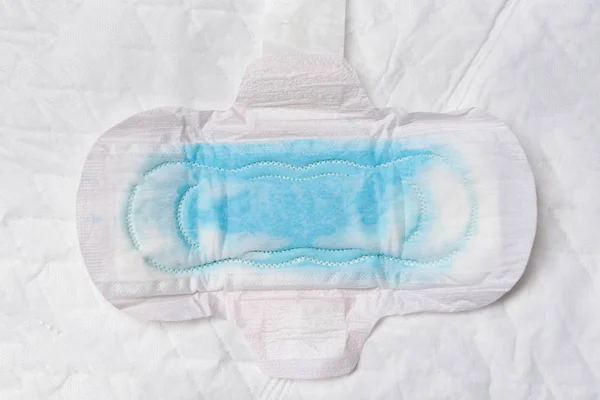 Guardanapo sanitário ou almofada sanitária feminina com teste de água azul — Fotografia de Stock