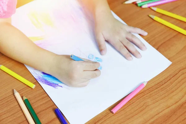 Girl painting on paper sheet with colour pencils on the wooden t — Stock Photo, Image