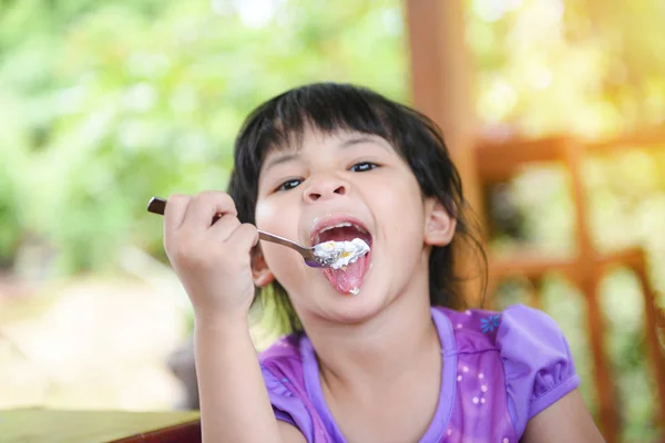Cute little girl eating cake / Asian child happy and holding a s — Stock Photo, Image