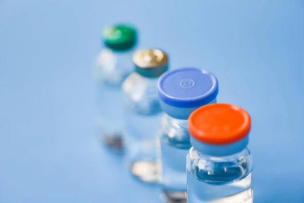 Flacons de médicaments en verre pour seringue aiguille d'injection sur le dos bleu — Photo