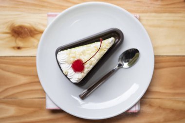 Beyaz palte o üzerinde kiraz meyve ve krem ile Kek dilim üst görünümü