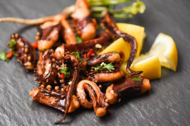 koyu arka plan üst limon otlar ve baharatlar ile ahtapot salatası