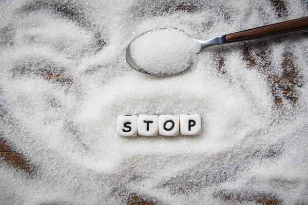 no sugar stop text blocks with white sugar on spoon wooden backg
