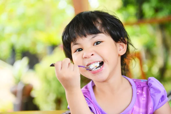 Menina bonito comer bolo - criança asiática feliz e segurando um s — Fotografia de Stock