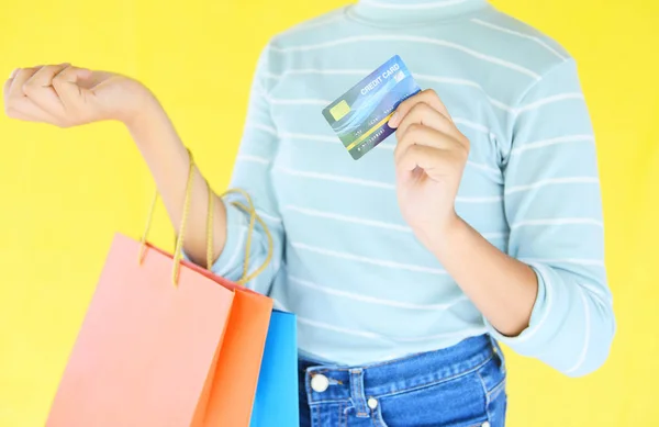 Woman hands holding credit card and holding shopping bag on yell