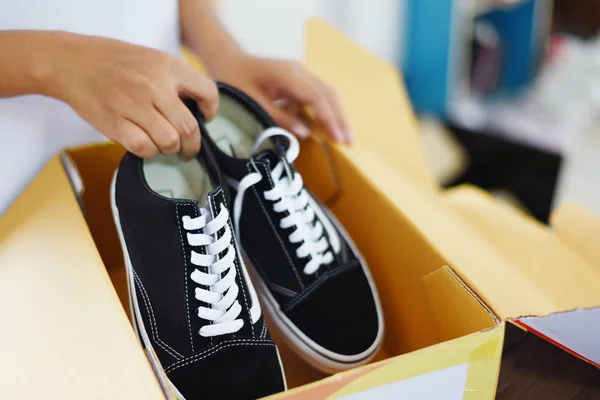 Продажа онлайн покупок / Женщина упаковки обуви кроссовки в cardbo — стоковое фото