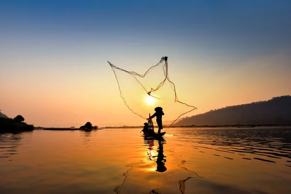 Asia fisherman net using on wooden boat casting net sunset or su — Stock Photo, Image