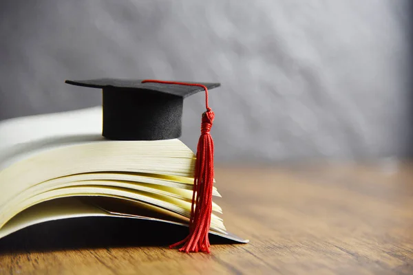 Concept d'éducation avec chapeau de graduation sur un livre sur la ta en bois — Photo