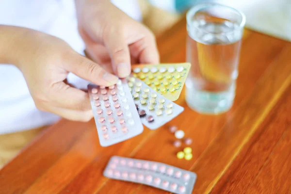 Mulher segurando pílulas anticoncepcionais na mão - Controle de natalidade contra — Fotografia de Stock