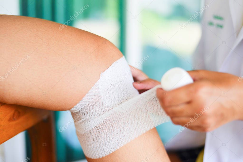 wound bandaging an injured knee from fall by nurse - first aid l