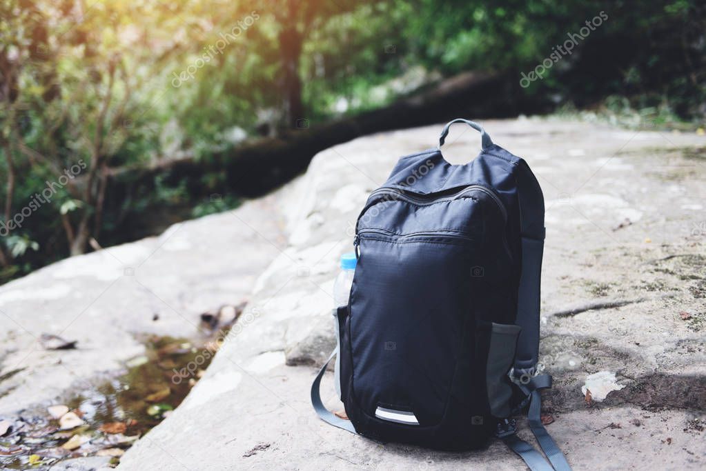 Backpack on nature with bottle for backpacker hiker on the rock 