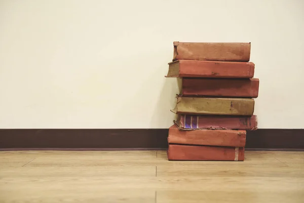 Livres anciens sur un plancher de bois - pile de livres dans la salle de bibliothèque pour — Photo