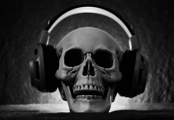 Totenkopf-Musik mit Kopfhörer - menschlicher Schädel hört Musik — Stockfoto