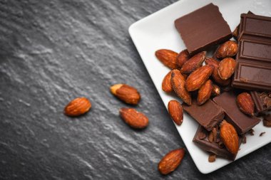 koyu backgr beyaz plaka üzerinde badem fındık ile çikolata