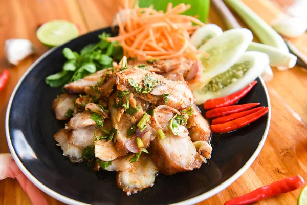 Свиной салат на гриле Тайская еда подается на столе с травами и шпиком — стоковое фото