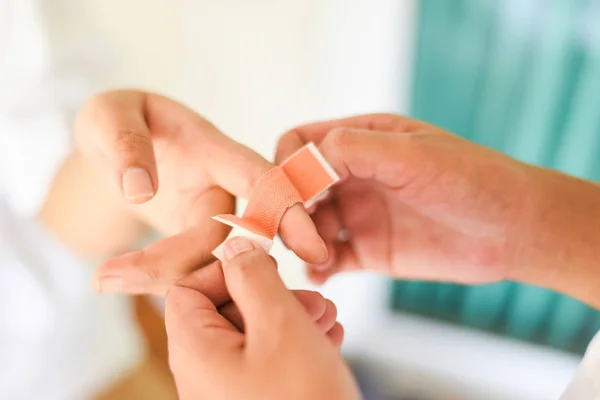 Finger wound bandaging an injured by nurse - first aid finger in