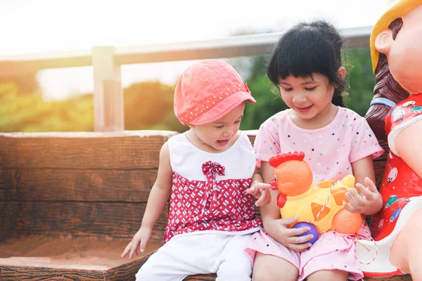 Children having fun playing outside Asian kids girl sitting on a — Stock Photo, Image