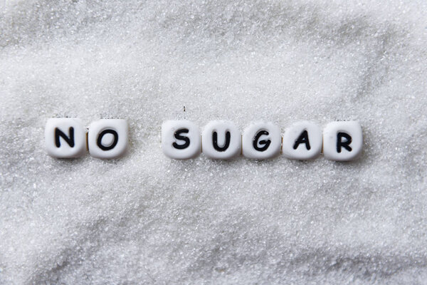 no sugar text blocks with white sugar with ant on wooden backgro