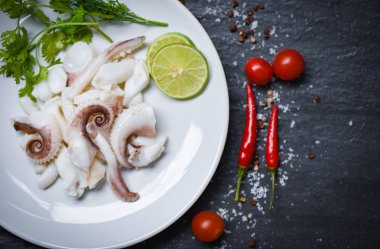 koyu arka plan üst v limon otlar ve baharatlar ile kalamar salatası