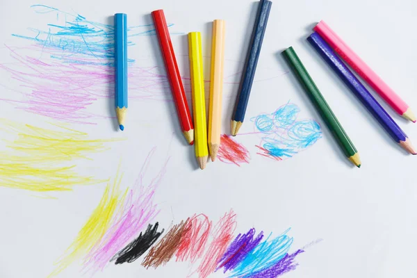 Lápices de colores sobre papel blanco concepto de educación sobre pintura de fondo — Foto de Stock