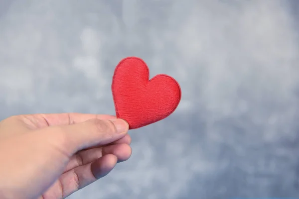 Hayırseverlik kavramı için eldeki kalp - adam kırmızı kalp i tutan — Stok fotoğraf