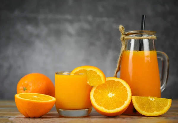 Jus d'orange dans le bocal en verre et tranche d'orange fraîche sur wo — Photo