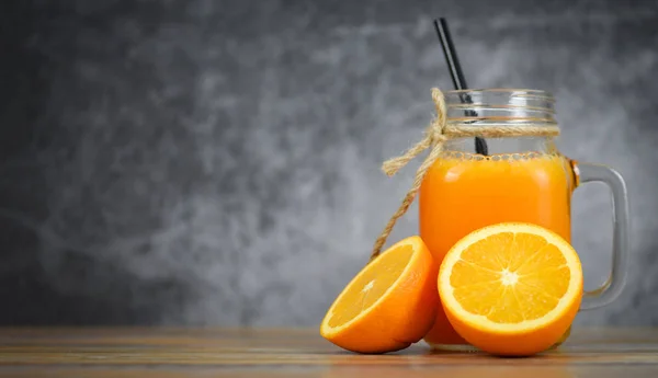 Jus d'orange dans le bocal en verre et tranche d'orange fraîche sur wo — Photo