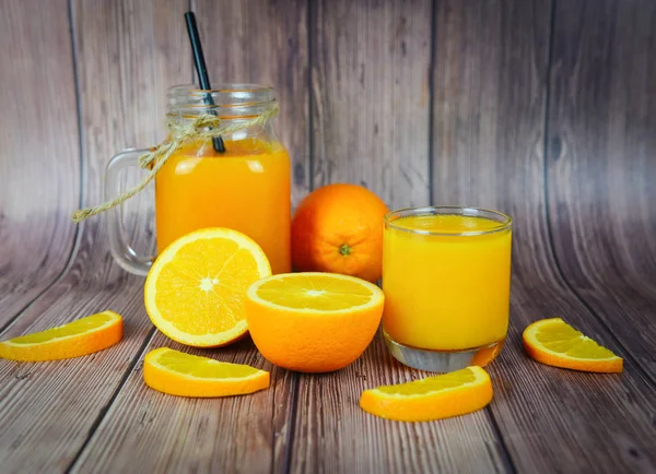 Jus d'orange dans le bocal en verre et tranche d'orange fraîche sur wo — Photo