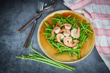 Kızarmış kuşkonmaz karides karides ahşap tabak ve f üzerinde yemek pişirme