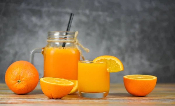 Jus d'orange dans le bocal en verre et tranche d'orange fraîche sur wo — Photo