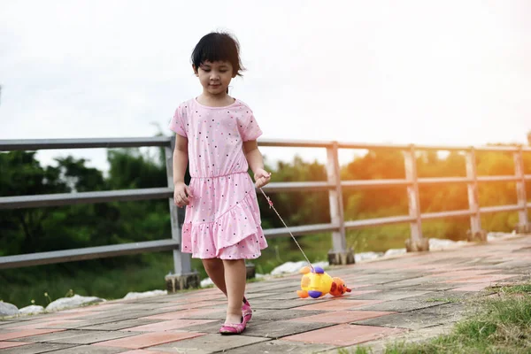 Child having fun playing outside Asian kid girl happy with toys — Stock Photo, Image