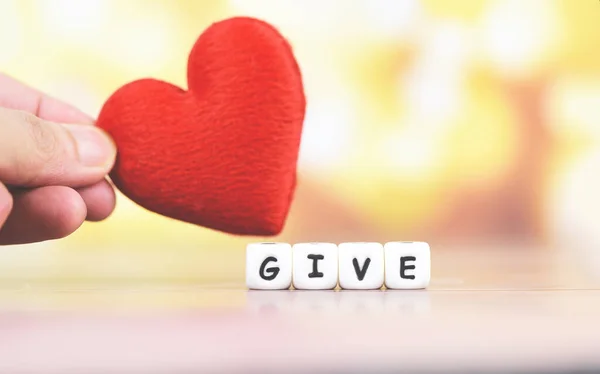 Liebe schenken mit rotem Herz in der Hand für Spenden und Wohltätigkeit hea — Stockfoto