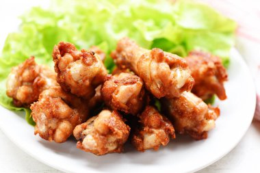 Sarımsak limon biber ot ile beyaz tabakta kızarmış tavuk kanatları