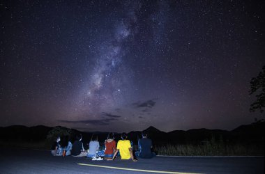 Turistlerle dolu Samanyolu Galaksisi yol kenarında oturuyor.