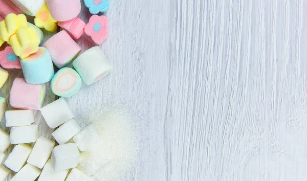 Açúcar branco, cubos de açúcar e doces coloridos na mesa — Fotografia de Stock