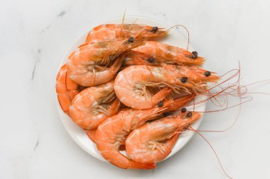 Beyaz tabakta karides / deniz ürünleri karidesleri yemek masasında servis edilir.