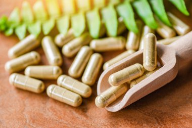 Tahta kepçe ve yeşil yaprak / bitkisel kapsüller üzerindeki bitkisel ilaçlar doğadan elde edilir. Sağlıklı yaşam tarzı.