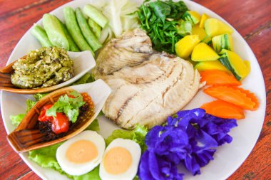Biber soslu buharda balık haşlanmış yumurta ve sebzeli balkabağı havucu beyaz tabakta / Tayland yemeği Asya tilapia balığı pişirdi 