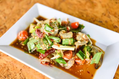 Çiğ karides salatası / Tayland usulü baharatlı deniz ürünleri sosu karides salatası beyaz tabakta 