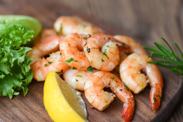 Салат креветки на гриле вкусные специи приправы на деревянной резки доски фон / аппетитные приготовленные креветки печеные креветки, морепродукты шелфиш с розмарином лимон и салат 