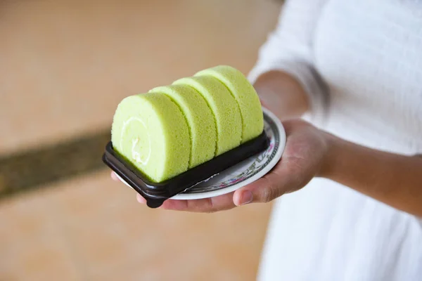 cake roll on plate / woman served green cake roll pandan with cream