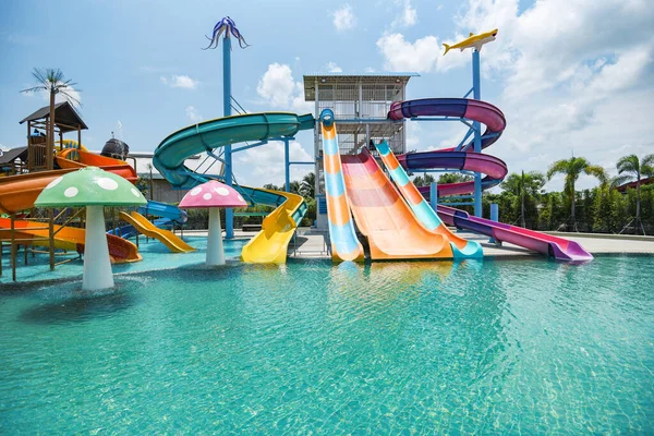 water park slide with swimming pool at amusement park / colored plastic water slides with pool in outdoor aqua park
