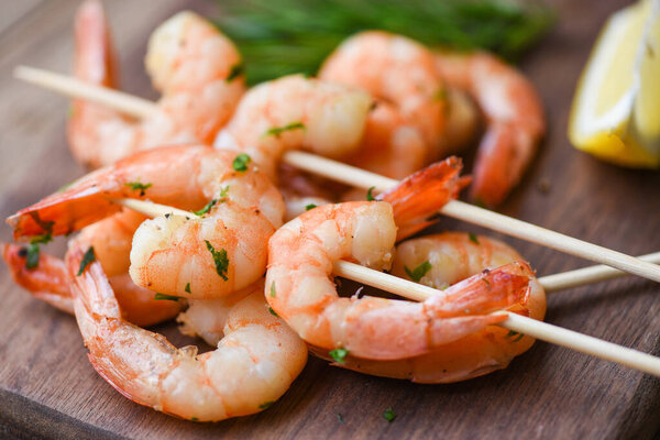 Салат гриль креветки шампуры вкусные приправы специи на деревянной тарелке аппетитные приготовленные креветки печеные креветки, морепродукты шелфиш с розмарином и лимоном
