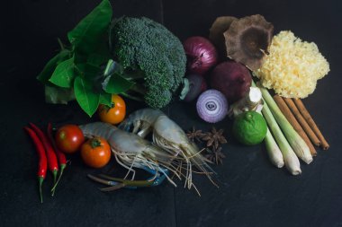 Siyah arka plan üzerine pişirmeden önce sebze ile karides